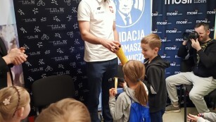 Dzieci wręczają Michałowi Szybie wykonany przez nich medal i puchar