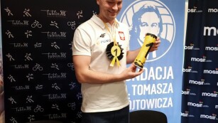 Michał Szyba prezentuje otrzymany od dzieci puchar i medal