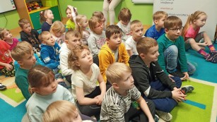 Zdjęcie grupowe. Dzieci słuchają wypowiedzi Michała Szyby
