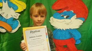 Chłopiec prezentuje dyplom zdobyty w konkursie