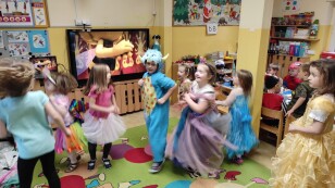 Sala przedszkolna. Dzieci przebrane w stroje karnawałowe uczestniczą w zabawie tanecznej.