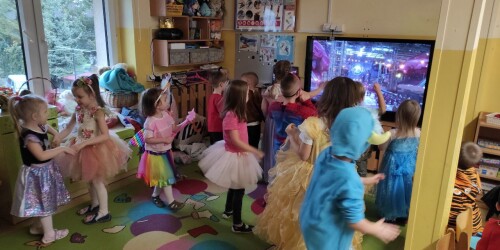 Sala przedszkolna. Dzieci przebrane w stroje karnawałowe uczestniczą w zabawie tanecznej.