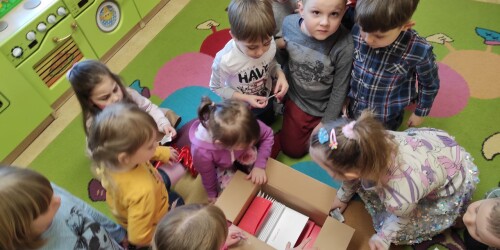 Dzieci zaglądają do pudła z prezentem