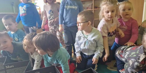 Dzieci patrzą na planety   w książce o kosmosie.