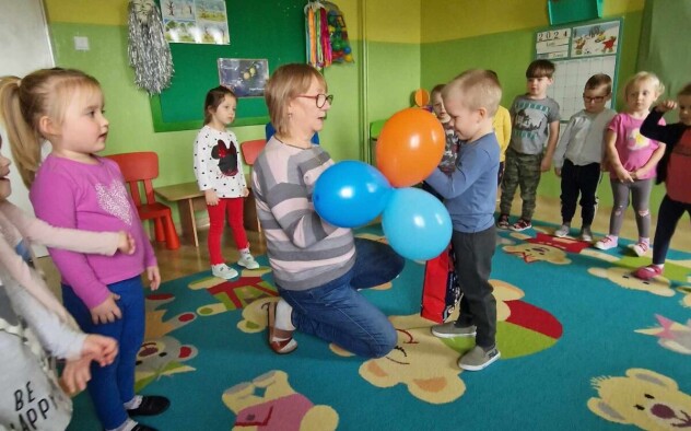 Kobieta wręcza chłopcu balony