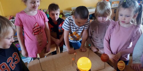 Dzieci oglądają ruchomy model Układu Słonecznego