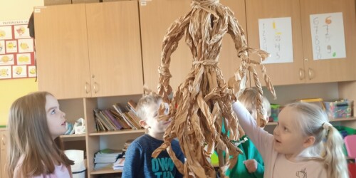 Dzieci prezentują wykonaną przez siebie papierową kukłę marzanny