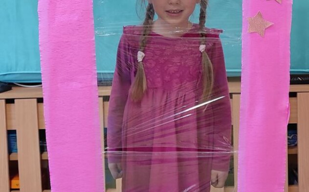 Dziewczynka przebrana za Barbie w fotobudce na kształt pudełka na lalkę Barbie