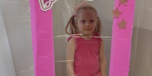 Dziewczynka przebrana za Barbie w fotobudce na kształt pudełka na lalkę Barbie