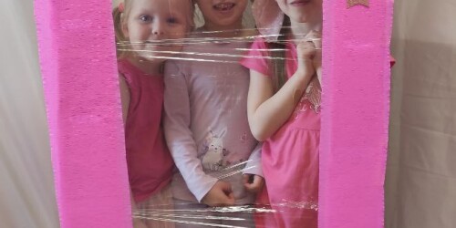 Trzy dziewczynki przebrane za Barbie w fotobudce na kształt pudełka na lalkę Barbie